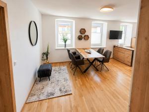 a dining room and living room with a table and chairs at Murleben Top 05 in Stadl an der Mur
