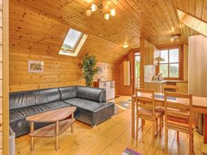 a living room with a leather couch and a table at Karawankenpanorama S in Liebenfels
