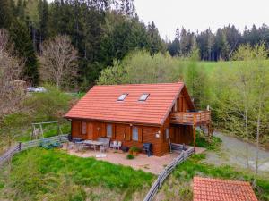 a log cabin with a red roof on a hill at Karawankenpanorama S in Liebenfels +10 photos