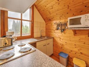 a kitchen in a log cabin with a sink and a microwave at Karawankenpanorama S in Liebenfels