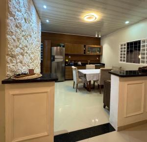 a kitchen and dining room with a refrigerator and a table at Casa Larissa in Presidente Figueiredo +10 photos