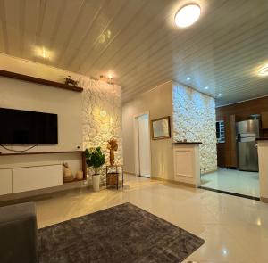a living room with a tv on a wall at Casa Larissa in Presidente Figueiredo