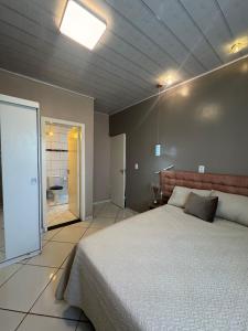 a bedroom with a large bed and a bathroom at Casa Larissa in Presidente Figueiredo