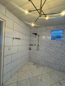 a room with a wall with a shower in it at Casa Larissa in Presidente Figueiredo