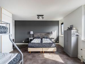 a bedroom with a bed and two bunk beds at De Brouwersdam in Ouddorp
