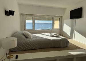 ein Schlafzimmer mit einem großen Bett und einem Fenster in der Unterkunft Boulevard 10 - Dúplex frente al mar con balcón y vista panorámica in Puerto Madryn