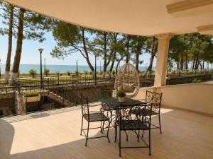 a table and chairs on a patio with a view of the ocean at Megobroba Hotel in Kobuleti
