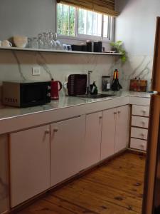 a kitchen with white cabinets and a microwave at Dpto Plaza Colon in Azul +7 photos