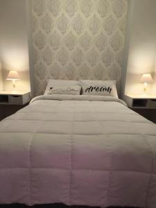 a bedroom with a white bed with two lamps at Dpto Plaza Colon in Azul