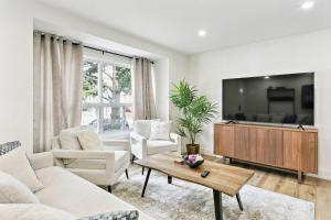 a living room with a couch and a tv at Modern 3BR Home, Minutes to Lake & Port Credit in Mississauga