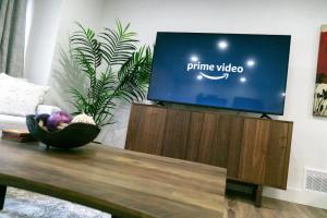 a flat screen tv sitting on top of a coffee table at Modern 3BR Home, Minutes to Lake & Port Credit in Mississauga +22 photos