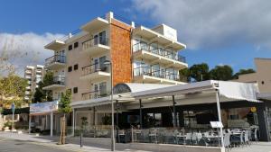 a building with tables and chairs in front of it at Hotel Creta Paguera in Paguera