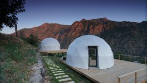 two domes on a wooden deck with mountains in the background at Glamping Yeghegis in Yeghegis