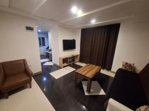 a living room with a couch and a table and a television at emplus in Batumi