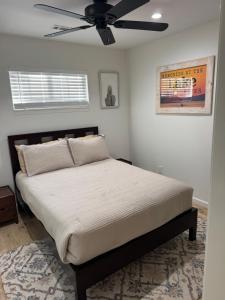 a bedroom with a bed with a ceiling fan at Cute cottage in Sunrise Beach in Sunrise Beach