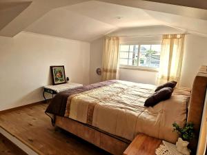 a bedroom with a large bed and a window at Private Pool House Minutes from the Beach in Charneca