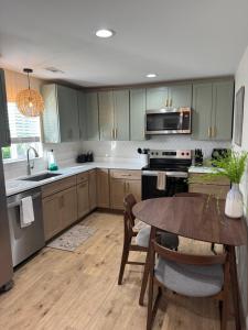 a kitchen with green cabinets and a table and a sink at Cute cottage in Sunrise Beach in Sunrise Beach