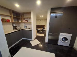 a small kitchen with a washer and a washing machine at emplus in Batumi