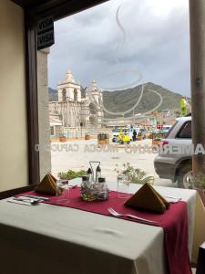 ein Tisch mit Tischdecke und Blick auf eine Stadt in der Unterkunft Hostal Yaravi in Chivay