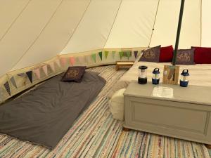 a tent with a bed and a table in it at Looe Valley Camping in Saint Keyne
