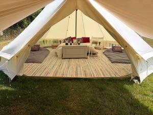a large tent with a table in the grass at Looe Valley Camping in Saint Keyne