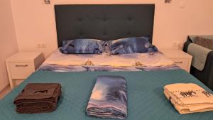 a bed with two pillows and towels on it at Studio Lucian in Douăzeci şi Trei August