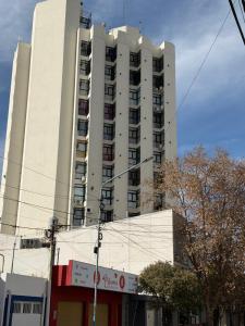 a tall white apartment building on a city street at Los Recoletos in Villa Mercedes