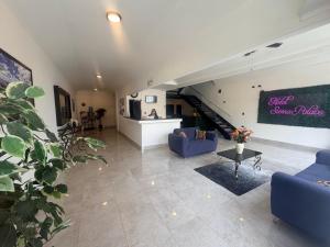 a living room with blue couches and a staircase at Hotel sierra palace in Cuauhtémoc