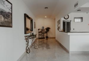 a hallway with white walls and a mirror at Hotel sierra palace in Cuauhtémoc