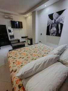 a bedroom with a large bed with a painting on the wall at Hotel sierra palace in Cuauhtémoc +5 photos