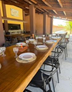 a long wooden table with plates and glasses on it at Hotel Fazenda Alta Vista in Fortim