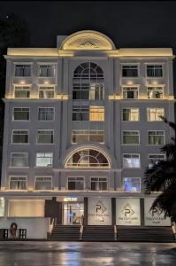 a large white building at night at Daró - Self Check-in - 1 BR Apartment - Gulberg - MM Alam - Pool in Lahore