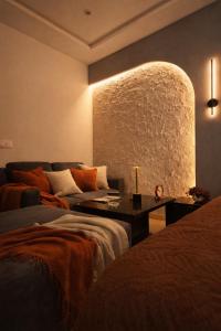 a living room with a couch and a large stone wall at Daró - Self Check-in - 1 BR Apartment - Gulberg - MM Alam - Pool in Lahore +29 photos