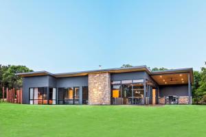 a modern house with a green lawn at Artisan Gunyulgup - Luxe Lakeside Wellness Hideaway in Yallingup