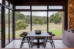 a table and chairs in a room with a large window at Artisan Koorabin - Lakeside Luxe Retreat next to Spa in Yallingup +17 photos
