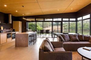 a large living room with a couch and a kitchen at Artisan Koorabin - Lakeside Luxe Retreat next to Spa in Yallingup