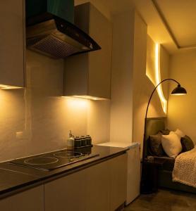 a small kitchen with a stove and a bed at Daró - Self Check-in - 1 BR Apartment - Gulberg - MM Alam - Pool in Lahore
