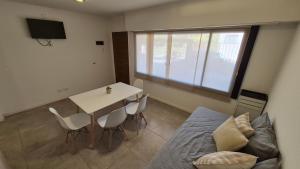 a living room with a table and a bed and a window at La Escondida in Chascomús