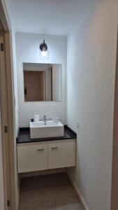 a bathroom with a white sink and a mirror at La Escondida in Chascomús +3 photos