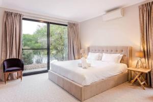 a bedroom with a large bed and a large window at Bonnie - Lakeside Relaxation surrounded by Wineries in Wilyabrup