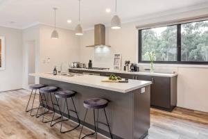 a kitchen with a large island with bar stools at Bonnie - Lakeside Relaxation surrounded by Wineries in Wilyabrup