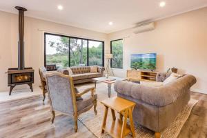 a living room with a couch and a fireplace at Bonnie - Lakeside Relaxation surrounded by Wineries in Wilyabrup