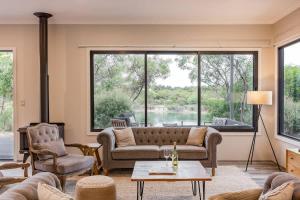 a living room with a couch and a large window at Bonnie - Lakeside Relaxation surrounded by Wineries in Wilyabrup +23 photos
