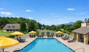 a swimming pool with chairs and umbrellas at The Parkman Great Smoky Mountains - Cades Cove in Townsend