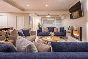 a living room with blue couches and a fireplace at 'Azure' Beachside Resort Escape for Groups in Marybrook