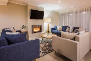 a living room with two couches and a fireplace at 'Azure' Beachside Resort Escape for Groups in Marybrook +30 photos