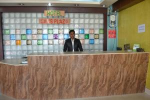 a man standing behind a counter in a hotel lobby at Hotel Shams Plaza in Cox's Bazar