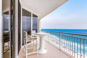 a balcony with a table and chairs and the ocean at Spacious Gulf Front Condo with Private WD and Shared Pool in Navarre
