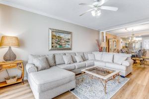 a living room with a couch and a table at Spacious Gulf Front Condo with Private WD and Shared Pool in Navarre