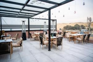 a restaurant with tables and chairs on a patio at Le Pacha Pyramids Hotel in Cairo